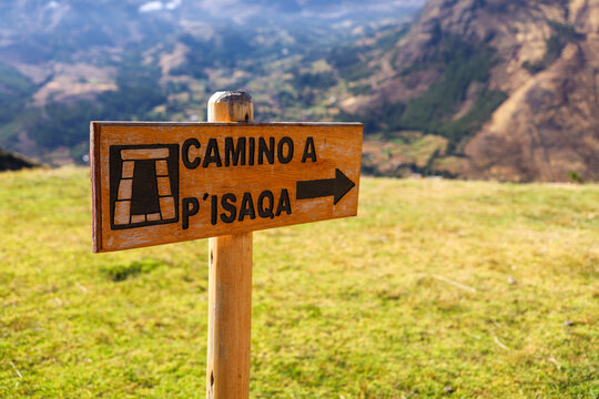 View of a wooden sign pointing towards the archaeological site of Pisac with mountains in the background in Cusco, Cusco, Peru.