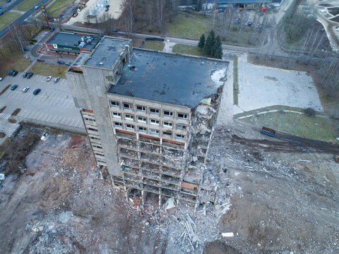 Riga, Latvia - 10 December 2017: Aerial view of a partially demolished concrete high-rise building with exposed structural elements and rubble on the ground.