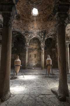 View of the ancient stone columns and domed ceiling with an oculus in the historic Arab Baths in Palma, Balearic Islands, Spain.