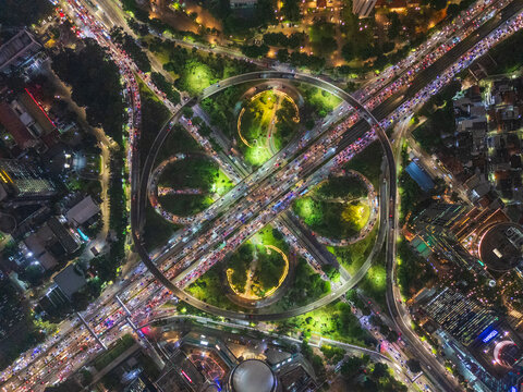 Jakarta, Jakarta, Indonesia - 06 May 2024: Aerial view of Simpang Susun Semanggi at night, showing the illuminated cloverleaf interchange with heavy traffic flow.