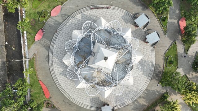 Majalengka, West Java, Indonesia - 15 July 2023: Aerial view of Alun-Alun Majalengka with its lotus-shaped structure, circular paved plaza, and surrounding lush greenery.