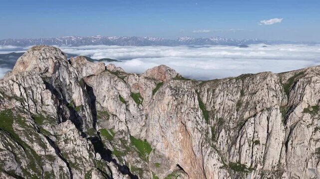 4K UHD Drone Flight Above Dramatic Rocky Mountain Ridge and Sea of Clouds.
