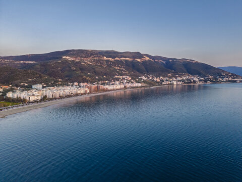 Aerial view of the coastal city of Vlora nestled between the Adriatic Sea and the surrounding mountains in Vlora, Vlore County, Albania.