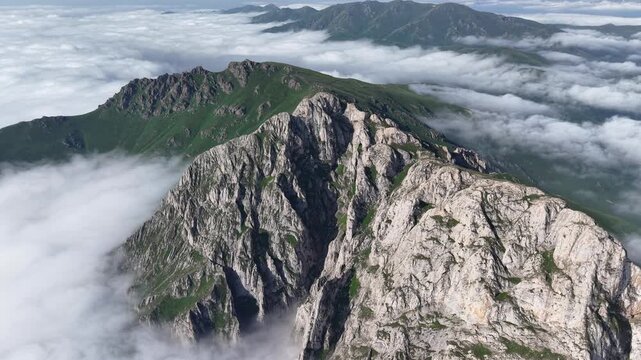 4K UHD Drone Flight Above Dramatic Rocky Mountain Ridge and Sea of Clouds.