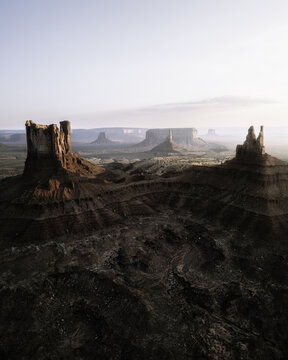 Aerial view of the iconic sandstone buttes and vast desert landscape of Monument Valley under soft morning light in Oljato-Monument Valley, Arizona, United States.