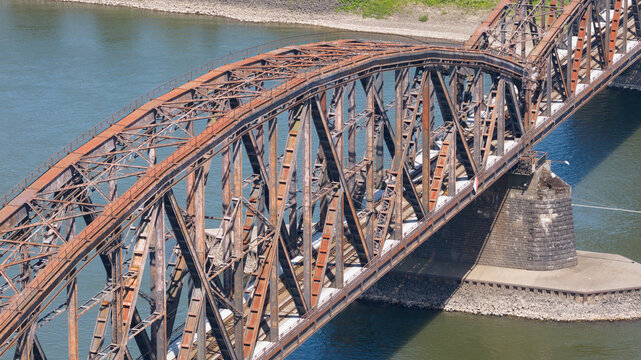 Aerial view of the historic Haus-Knipp railway bridge spanning the river with its intricate steel truss structure and stone piers in Duisburg, North Rhine-Westphalia, Germany.