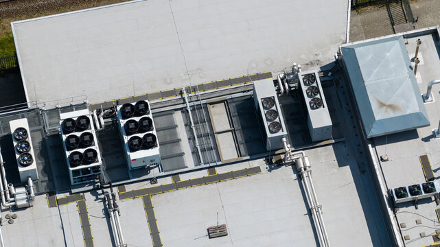 Aerial view of industrial HVAC units and cooling fans installed on a flat commercial building roof in Nieuwegein, Utrecht, Netherlands.