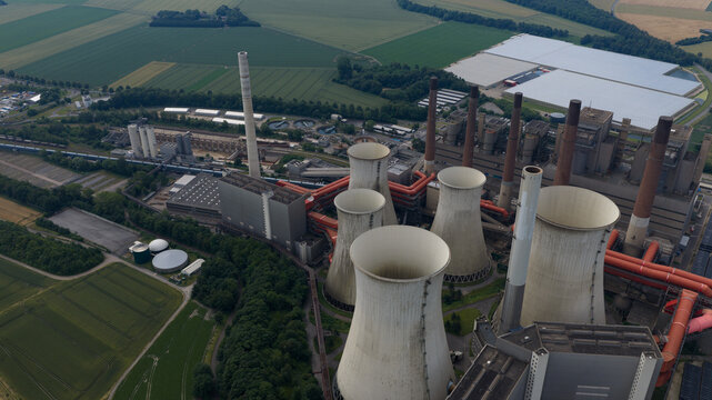 Aerial view of Kraftwerk Niederaussem, a large coal-fired power plant with cooling towers and industrial infrastructure in Bergheim, Nordrhein-Westfalen, Germany.