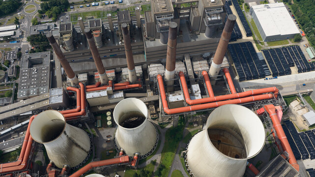 Aerial view of Kraftwerk Niederaussem with its large cooling towers, tall chimneys, and complex network of industrial pipes in Bergheim, Nordrhein-Westfalen, Germany.
