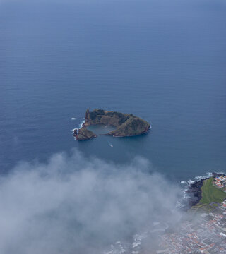 Aerial view of Ilheu de Vila Franca do Campo, a volcanic islet with a natural circular crater lagoon surrounded by the Atlantic Ocean near the coast of Sao Pedro, Acores, Portugal.