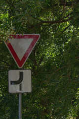 Road sign in the tree, with a marked main and side road.  © Enjoy_Travel