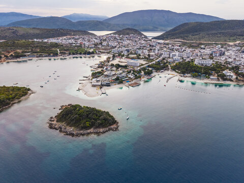 Aerial view of the coastal town of Ksamil featuring turquoise waters, small islands, and surrounding hills in Ksamil, Vlore County, Albania.