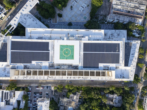 Aerial view of the Centro Internacional de Congresos de Yucatan featuring rooftop solar panels and a helipad in the urban landscape of Merida, Yucatan, Mexico.