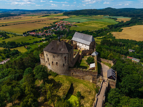 Aerial view of Tocnik Castle surrounded by lush green forests and rolling fields in Tocnik, Stredocesky kraj, Czechia.