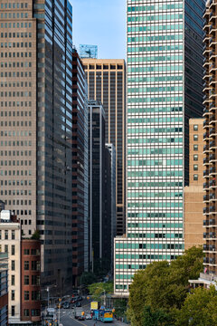 Elevated view of Water Street in downtown Manhattan surrounded by tall skyscrapers, modern office towers, historic architecture, and street traffic in the financial district of New York City.