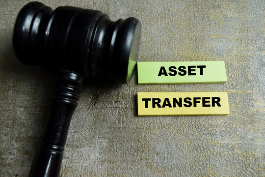 Concept of asset transfer write on sticky notes isolated on Wooden Table. For legal ownership change financial transaction