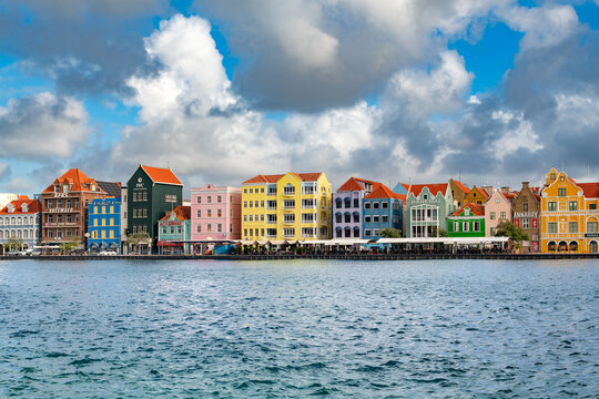 Panoramic view of traditional colorful Dutch colonial architecture buildings along the famous waterfront in Willemstad, Curacao, with vibrant historic facades.