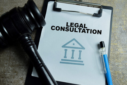 Concept of legal consultation write on clipboard with judge gavel isolated on Wooden Table. For legal advice and law firm