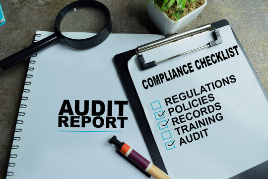 Concept of audit and compliance write on clipboard with business report, checklist isolated on Wooden Table.