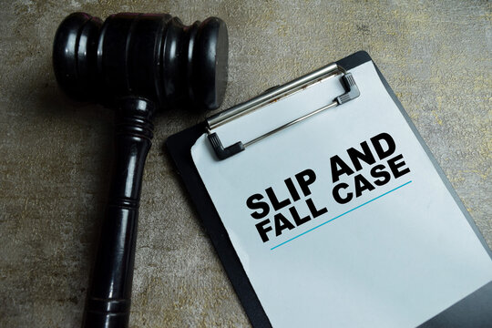 Concept of slip and fall case write on clipboard with judge gavel isolated on Wooden Table. For personal injury lawsuit and legal liability