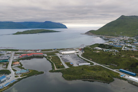 Aerial view of the town of Unalaska nestled between green mountains and the bay in Unalaska, Alaska, United States.