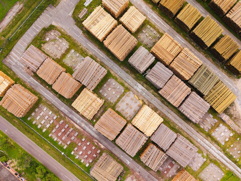 Aerial view of stacks of cut timber and logs arranged in neat rows at a lumber yard in Brankas, Jelgava Municipality, Latvia.