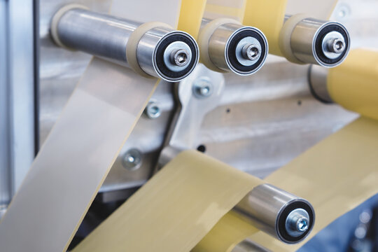 Fragment of   tape sticking labeling machine conveyor  for labeling packaging. Abstract industrial background, tech industrial technology background