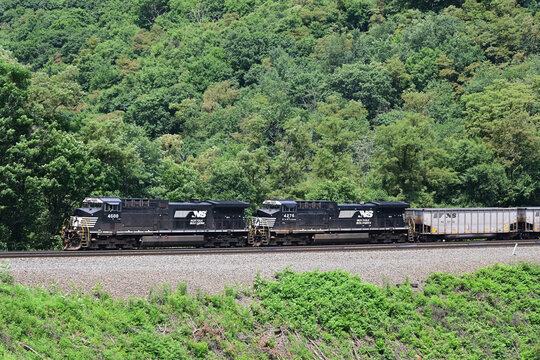 A pair of Norfolk Southern Railway locomotives lead an empty coal train westbound upgrade through Horseshoe Curve in western Pennsylvania. 