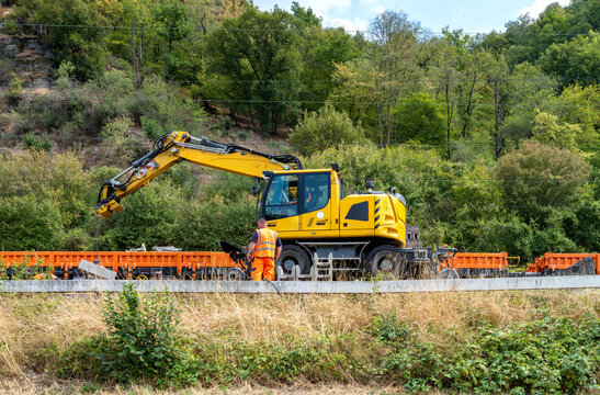 Rail construction with a road rail excavator during railway modernization in the Rhine Valley