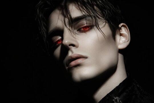 Portrait of a mysterious young man with glowing red eyes in the dark. Gothic vampire character concept for fantasy stories, horror movie poster, or mystical occult themed art projects.