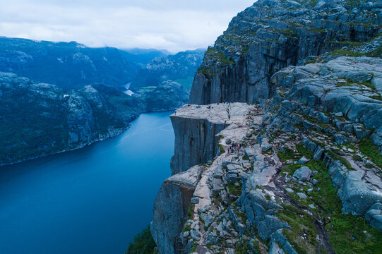 Aerial view of Pulpit Rock, a famous cliff formation overlooking the Lysefjord, with rocky terrain and hikers visible on the plateau in Strand, Rogaland, Norway.