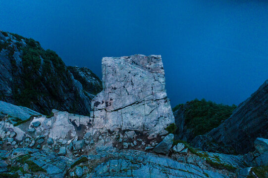 Aerial view of Pulpit Rock rising above the deep blue waters of Lysefjord with rugged cliff faces and rocky terrain in Strand, Rogaland, Norway.