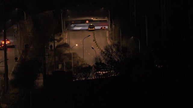 City night view of traffic lights at the entrance of highway underpass