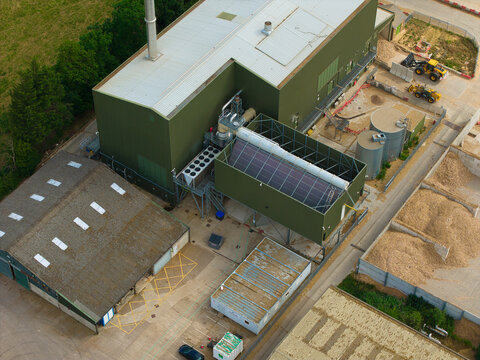 Aerial view of Widmerpool Biomass Powerplant showing industrial buildings, storage tanks, piles of wood chips, and machinery in the yard in Widmerpool, England, United Kingdom.