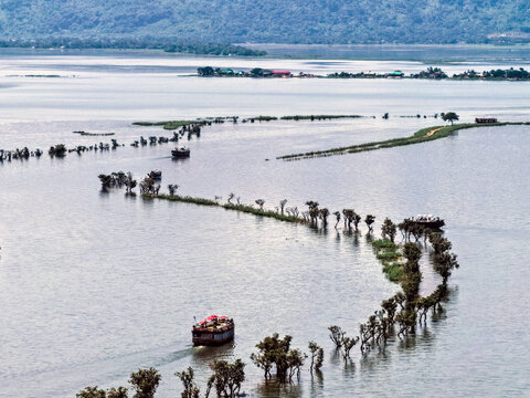 Tahirpur, Bangladesh - 03 July 2026: Aerial view of Jadukata River with boats navigating through partially submerged trees and lush vegetation in the wetlands of Sylhet Division.