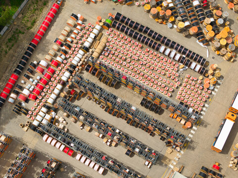 Aerial view of Eland Cables industrial site with rows of colorful cable reels and spools stored in an outdoor yard in Denaby Main, England, United Kingdom.