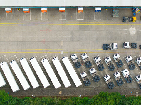Aerial view of an industrial distribution center with rows of white trailers and parked truck cabs at loading bays in Doncaster, England, United Kingdom.