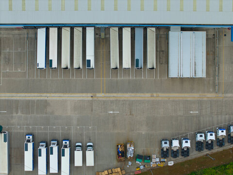 Aerial view of an industrial distribution centre with rows of parked HGVs and trailers at loading bays in a concrete yard in Doncaster, England, United Kingdom.