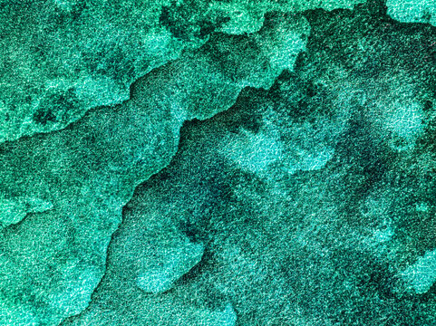 Aerial view of the textured surface of the ocean with vibrant turquoise and deep green hues in Mauritius.