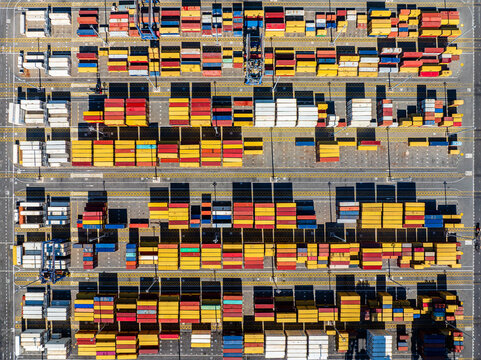 Aerial view of a busy container terminal with rows of colorful shipping containers stacked in a port in Mauritius.