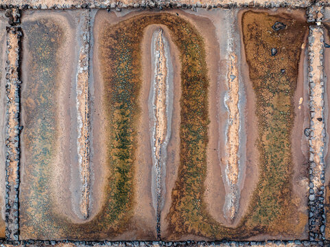 Aerial view of salt pans with geometric stone dividers and textured earth patterns in Mauritius.