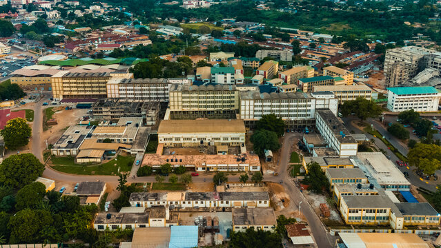 Aerial view of the Okomfo Anokye Teaching Hospital complex with its sprawling buildings, paved roads, and surrounding greenery in Kumasi, Ashanti Region, Ghana.