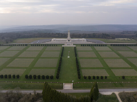 Aerial view of the Douaumont Ossuary, a historic memorial and cemetery with rows of white crosses set in green fields in Douaumont-Vaux, Grand Est, France.