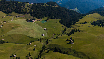 Obraz premium View of beautiful landscape in the Alps with fresh green meadows in the background on a sunny day with blue sky and clouds in summertime. Alpe de Siusi, Dolomite Alps