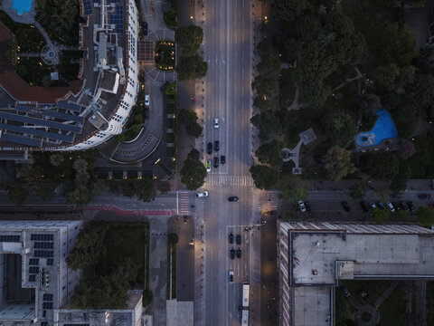 Aerial view of a city intersection with street lights illuminating the road and surrounding urban architecture in Tirana, Tirana County, Albania.