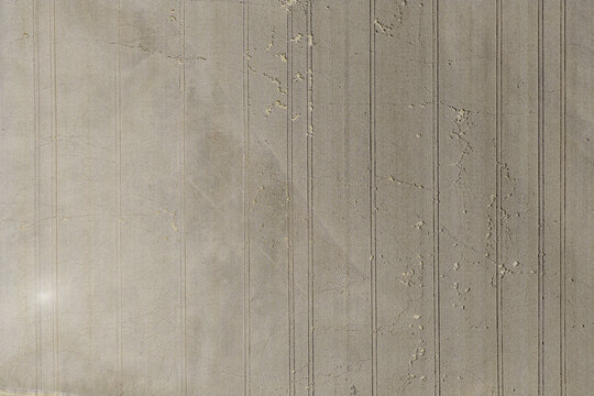 Aerial view of agricultural field with parallel tractor tracks and soil textures in Hombourg, Grand Est, France.
