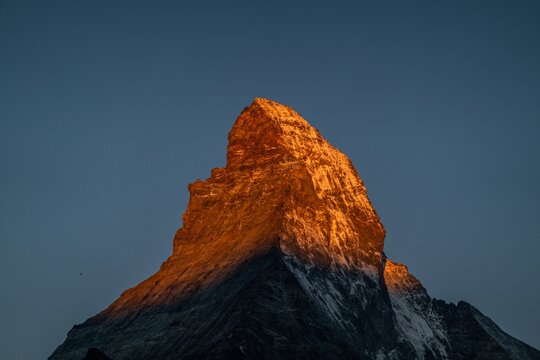 Sonnenaufgang &uuml;ber der markanten Spitze des Matterhorns in den Schweizer Alpen