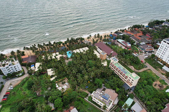Aerial view of Long Beach with lush palm trees, resort buildings, and a swimming pool along the tropical coastline in Phu Quoc, Kien Giang, Vietnam.