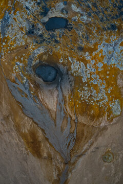 Aerial view of Hverir geothermal area featuring bubbling mud pools, steaming vents, and vibrant mineral deposits across the ochre and grey landscape in Reykjahlid, Thingeyjarsveit, Iceland.