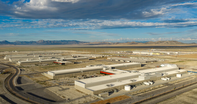Aerial view of the Eagle Mountain Data Center buildings set within a vast desert landscape with mountains in the background under a blue sky in Eagle Mountain, Utah, United States.